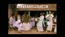 a group of people are dancing in front of a building and the website starttamilchat.in is visible