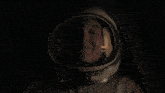 a woman wearing a space helmet is smiling with her eyes closed