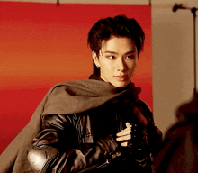 a man wearing a black leather jacket and a cape