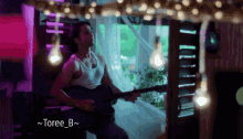 a man playing a guitar with the name toree_b written below him