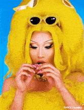 a picture of a drag queen with yellow hair and sunglasses taken by t4yce
