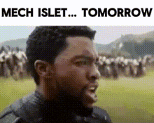 a man is standing in a field with a crowd of people in the background and says `` mech islet ... tomorrow '' .