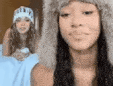 two women wearing hats are standing next to each other .