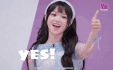 a girl in a blue dress giving a thumbs up with the word yes on the bottom