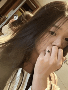 a woman with a ring on her finger takes a picture of herself