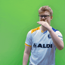 a man wearing glasses and a shirt that says aldi on it