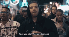 a man in a hooded jacket is standing in a crowd of people and says fuck you bitch