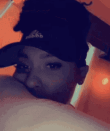 a close up of a person wearing a hat with the word adidas on it
