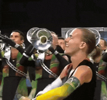 a man playing a trumpet in a marching band with the letter x on his arm