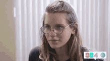 a close up of a woman wearing glasses and a black shirt .