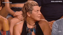 a woman is sitting in a crowd of people with the words in diretta della palapa on the bottom
