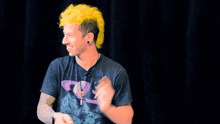 a man with yellow hair is wearing a black shirt