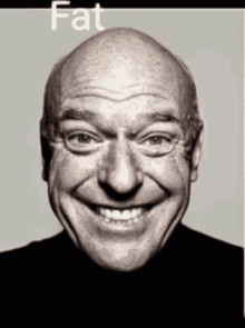 a bald man is smiling with the word fat written below him