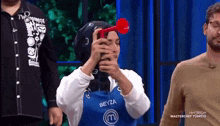 a woman in a blue apron with the letter m on it