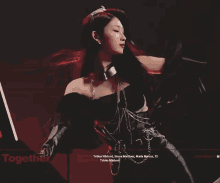 a woman in a black dress with a tiara on her head is holding a sword in front of a sign that says together
