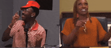 a man and a woman are sitting at a table with their hands up