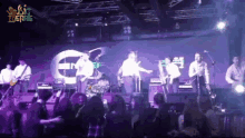a group of people playing instruments on a stage with a sign that says " music theatre "