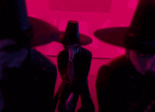 a group of people wearing black hats are standing in front of a pink wall