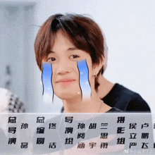 a man with chinese writing on his face has tears coming out of his eyes