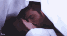 a man and a woman are kissing under a blanket with sophie written on the bottom