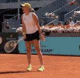 a woman is holding a tennis racquet on a tennis court in front of a rolex banner .