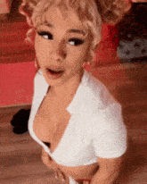 a woman in a white crop top with a plunging neckline is standing in a room .