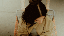 a woman sitting in a shopping cart with a person pushing her