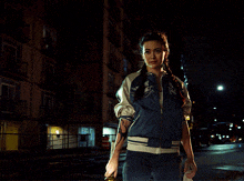 a woman in a blue jacket holds a torch
