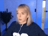 a woman wearing ear buds and a blue shirt with a bear on it