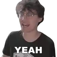 a man wearing glasses and a black shirt with the word yeah on it