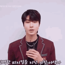 a young man in a suit is waving his hand in korean .