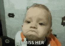 a baby is making a sad face and saying i miss her .