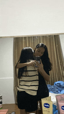 two women hugging in front of a vaseline lotion