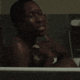 a man in a bathtub is crying and holding his hand to his face