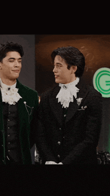 a man in a green jacket is standing next to a man in a black jacket