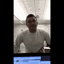 a man in a white shirt is standing in front of a computer