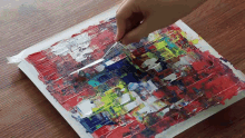 a person is using a brush to paint a colorful painting