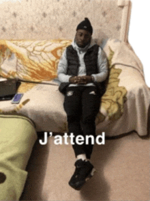 a man is sitting on a couch with the words j'attend written on the bottom