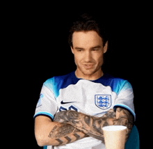 a man with tattoos on his arms is wearing a nike shirt with the number 50 on it
