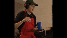 a man wearing headphones and an apron is holding a tray of food .