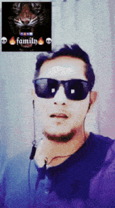 a man wearing sunglasses has a picture of a tiger behind him with the word family