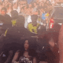 a woman is sitting in a car with a crowd of people behind her .