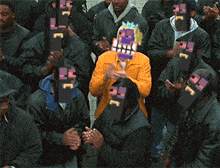 a man in a yellow jacket is surrounded by a group of men wearing masks with letters ec on them