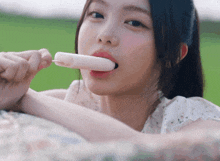 a young woman is eating a popsicle with her tongue out