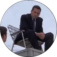 a man in a suit is sitting on a chair on top of a building