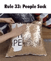 a person is holding a pillow that says people suck on it .