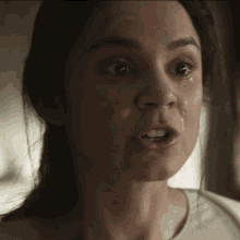 a close up of a woman 's face with a tear coming out of her eye