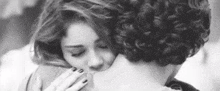 a black and white photo of a man and a woman hugging .