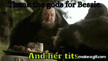 a man sitting at a table with a tray of food and the words " thank the gods for bessie and her tits "