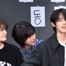 a group of people are standing in front of a wall with a sign that says uho on it